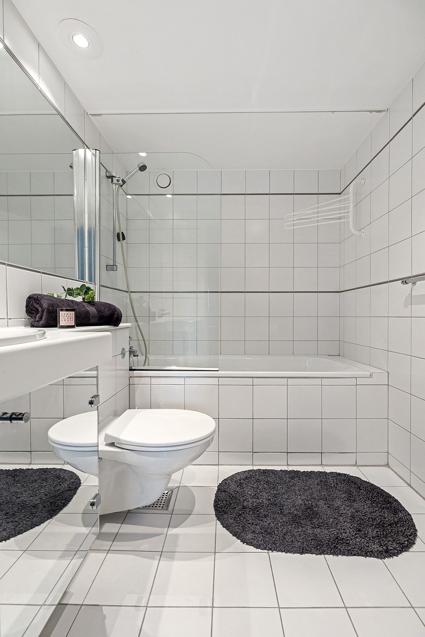 Small bathroom with pale tile, slim storage and a wall-hung basin