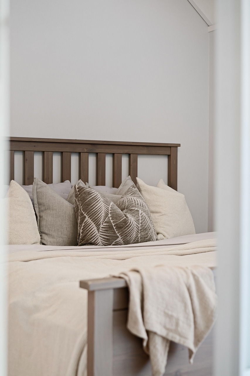 Restful bedroom with sheer curtains, trailing plants and a low wooden bench