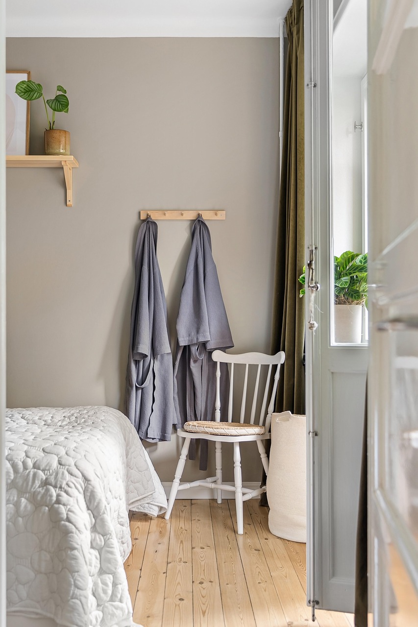 Bedroom with a tall upholstered headboard and layered linen bedding in muted tones
