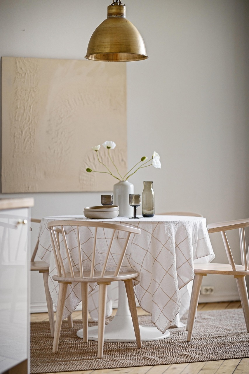 Styled dining nook with a vase, ceramic bowls and a brass pendant light