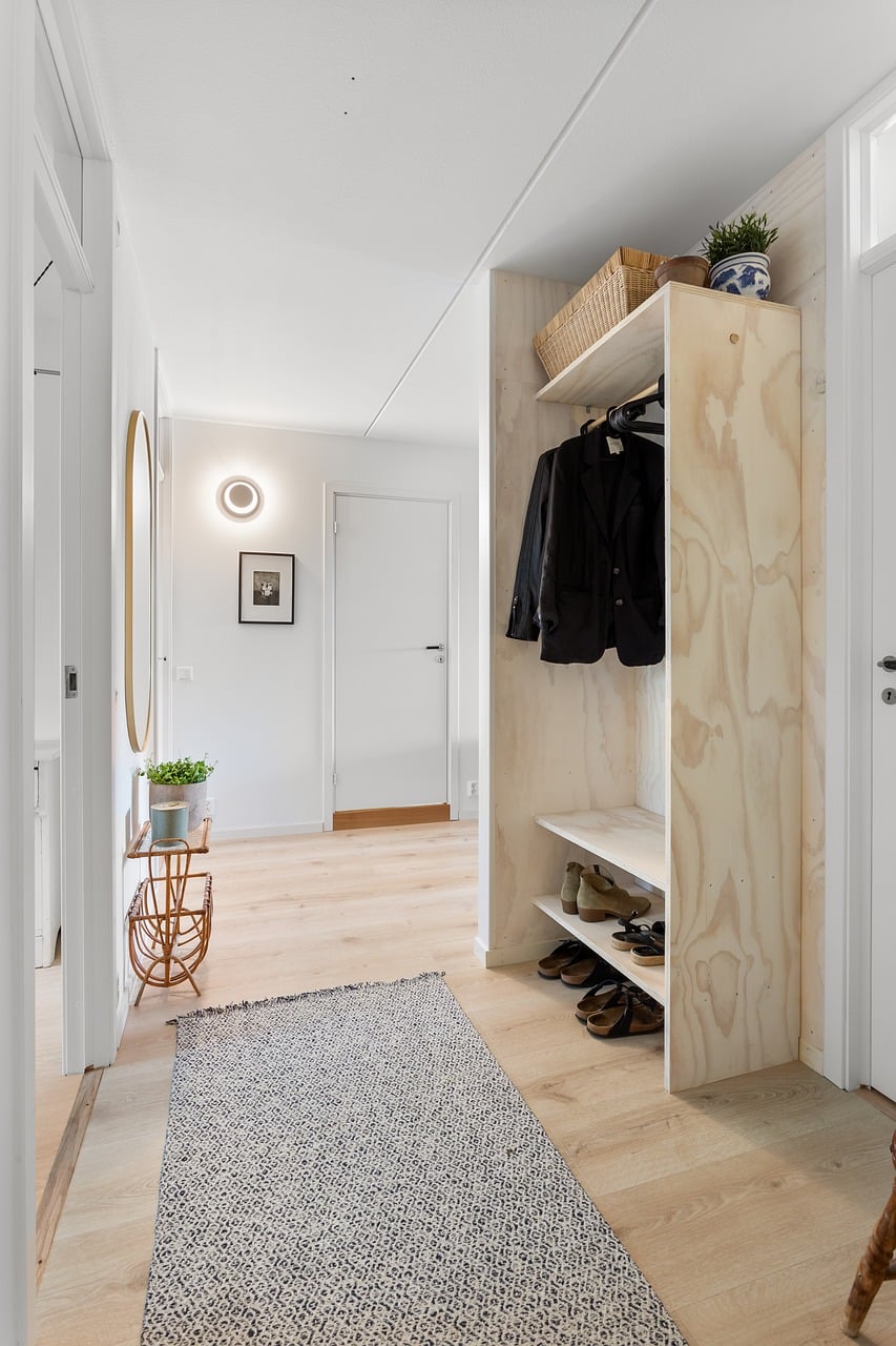 Entry hall with warm wood flooring and a soft runner rug leading inward